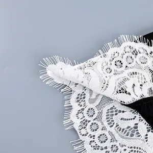 Detailed macro shot of premium white eyelash lace trim on a sexy black fashion garment