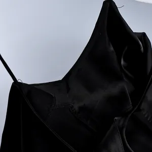Close-up detail of the neckline and fine stitching on a black satin camisole top.