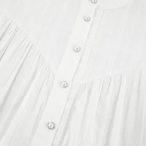 Close-up of a white French cotton shirt featuring elegant pearl buttons and lace texture