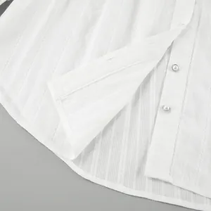 Close-up detail of a white French cotton blouse featuring elegant pearl buttons