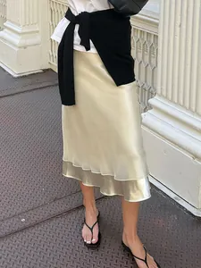 Elegante falda midi de satén champán con retales de malla transparente y bajo de sirena