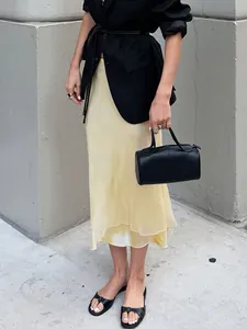 Elegante falda midi de satén amarillo con costura de malla transparente y diseño de sirena