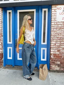 Close-up view of a stylish white lace patchwork camisole top in a street setting