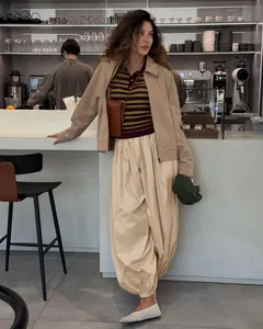 Stylish beige balloon harem trousers paired with white mesh flats in a cafe setting