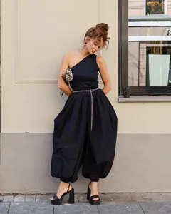 Full length outdoor view of chic black voluminous lantern pants and one-shoulder top