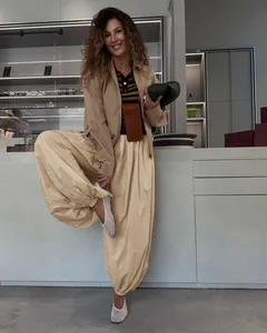 Stylish beige balloon pants with cuffed hem modeled in a modern boutique interior setting