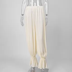 Detail van de crèmekleurige broek in Franse stijl met elegante pofzomen en ruches.
