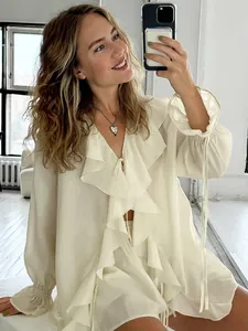 Schickes cremeweißes Set aus Rüschenbluse und Shorts für Damen in stilvoller Umgebung