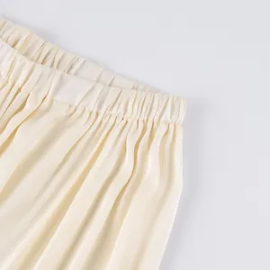 Detailopname van de elastische tailleband van deze ivoren geplooide joggingbroek