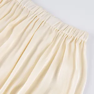 Detail van elastische tailleband en geplooide stof op crème Franse stijl joggingbroek