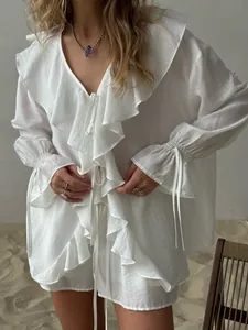 Detailansicht des weißen Rüschen-Cardigans mit Bindeband und Shorts-Set.