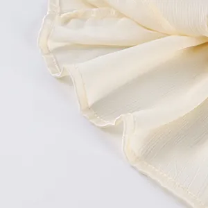 Detailopname van de elegante geplooide zoom van de crèmekleurige pofbroek in Franse stijl.