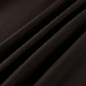 Detalle macro de los pliegues de tela de terciopelo marrón oscuro con textura rica