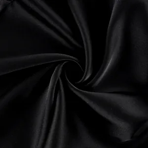 Close-up of smooth black satin fabric texture showing silky luster and elegant folds