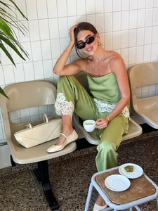 Stylish green satin camisole and trousers set with lace trim shown in a lifestyle scene