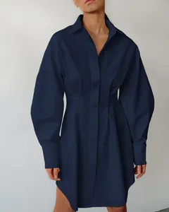 Gedetailleerde opname van de elegante marineblauwe getailleerde overhemdjurk voor dames.