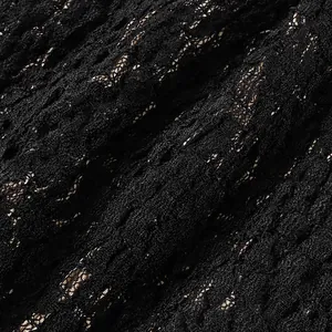 Detailed macro view of intricate black lace fabric on a sexy women's fashion camisole top