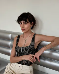 Elegant model showcasing a black floral lace camisole tank top styled with silver jewelry