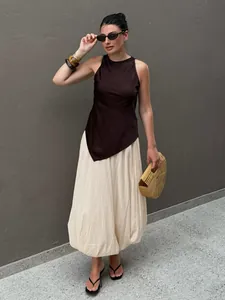 Tenue complète avec pantalon bouffant crème et haut marron asymétrique élégant.