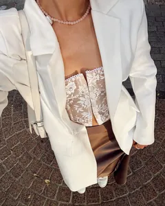 Close-up detail of white floral lace corset camisole top styled under a white blazer