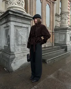 Elegant dark brown faux suede jacket with waist belt shown in retro urban setting