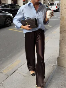 High-waisted brown satin wide-leg trousers in a chic street style outfit
