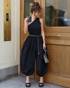 Stylish black one-shoulder balloon harem jumpsuit for women in a street setting