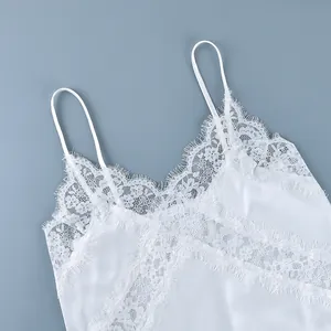 Detailed view of elegant white floral lace patchwork on a satin camisole strap top