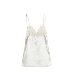 Close-up detail of elegant white satin camisole featuring delicate lace V-neck trim