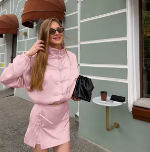 Ganzkörperaufnahme eines rosa Sets im chinesischen Stil mit Knebelknöpfen auf der Straße