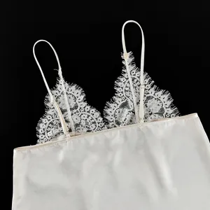 Close-up of elegant white satin camisole with delicate eyelash lace neckline details