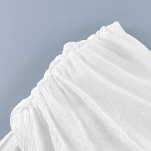 Detailweergave van de witte kreukstof van deze losse modieuze geplooide lantaarnbroek.