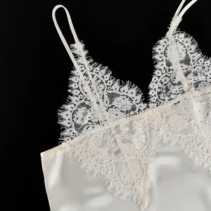 Close-up of white lace V-neck camisole with delicate eyelash trim and satin fabric