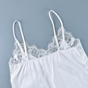 Detailed view of white satin camisole featuring delicate lace trim and adjustable straps
