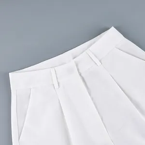 Detailed view of white high-waist casual wide-leg trousers showing pleats and fabric texture
