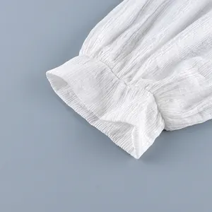 Detailopname van witte crêpestof en geplooid manchet op een dames lantaarnbroek