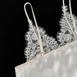Close-up detail of cream sexy V-neck camisole with delicate white eyelash lace trim