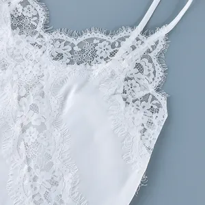 Close-up of white eyelash lace patchwork camisole with delicate floral patterns.