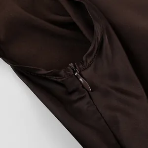 Close-up detail of smooth dark brown satin fabric with a hidden invisible zipper