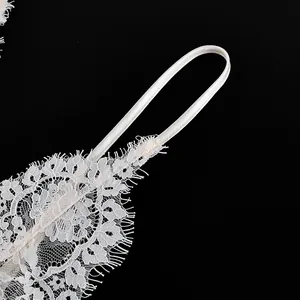 Close-up detail of exquisite white floral lace and satin strap on a camisole top