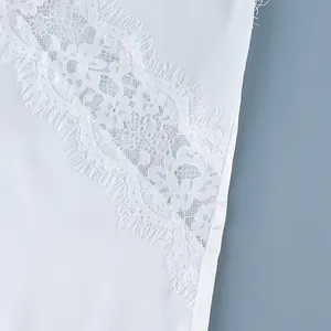 Macro detail view showing delicate white floral lace patchwork on sleeveless camisole top