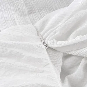 Close-up detail van de witte onzichtbare rits op een geplooide getextureerde broek