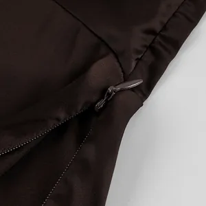 Close-up detail of an invisible zipper on brown satin fabric for smooth garment closure.
