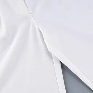 Detailed macro shot of white high-waisted wide-leg trousers showing fabric texture.