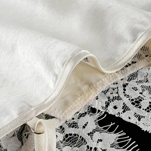 Close-up macro detail of elegant white satin fabric and delicate lace trim on camisole