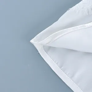 Detailed view of the fine white lace trim and precision stitching on this summer camisole