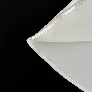 Macro detail of white camisole top hem showing professional satin binding stitch