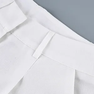 Close-up of white high-waist wide-leg trousers waistband and fabric texture