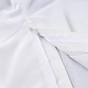 Close-up detail of smooth hidden zipper on white high-waisted wide-leg trousers fabric