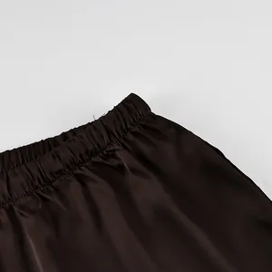 Detailed close-up view of dark brown satin pants featuring a comfortable elastic waistband